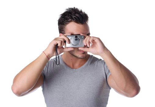 Attractive young man taking picture with compact photo camera