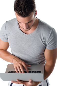 Attractive young man using laptop computer, isolated on white