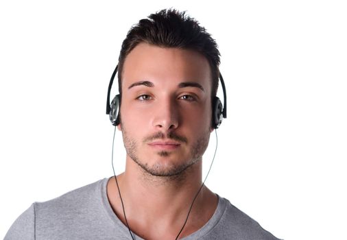 Handsome young man with headphones listening to music, isolated on white