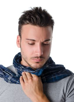 Young man with scarf, holding his neck because of throat ache with suffering expression