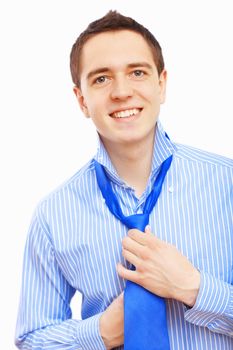 Young businessman at home preparing for a work and making his tie