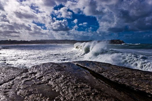 Wave rolling on to the rocky seashore in Yorkshire, England