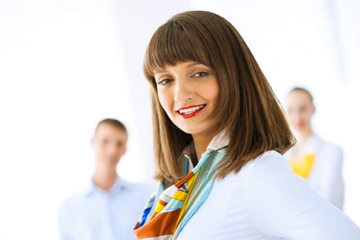 Portrait of a young successful business woman standing against colleagues