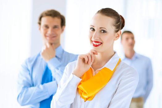 Portrait of a young successful business woman standing against colleagues