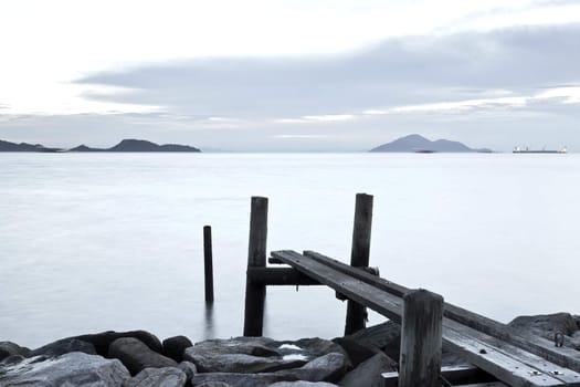 Clam sunset with jetty on sea