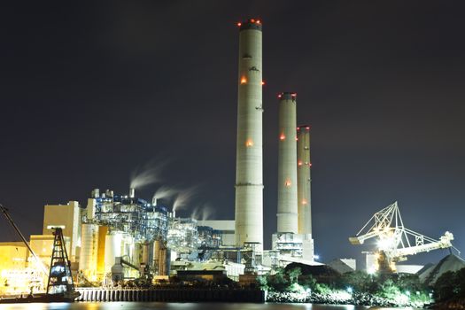 Smoking industrial power plant at night 