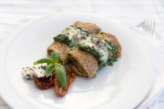 Delicious salty pancakes with spinach, gorgonzola, dried tomatoes and basil.