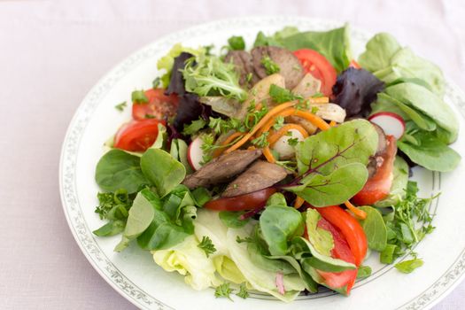 Delicious salad with fried rabbit liver and fresh vegetables.