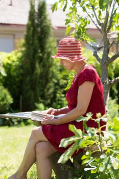 Serene modern aged woman reading book in her garden.