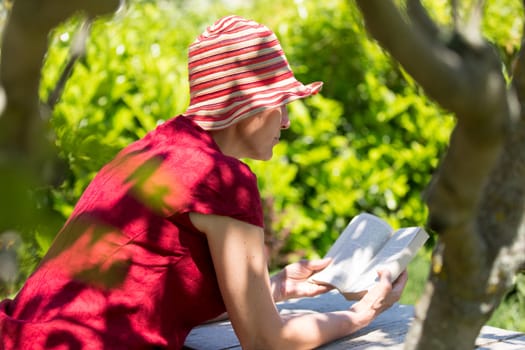 Serene mature woman reading book in her garden.