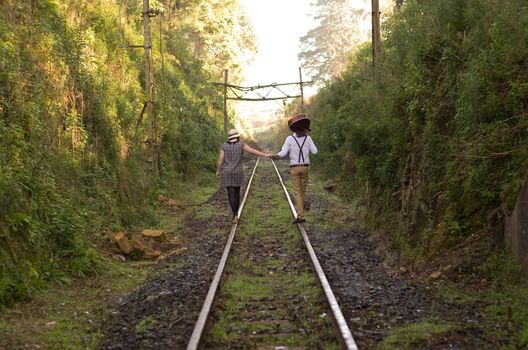 Retro hip hipster romantic love couple walking vintage train tracks