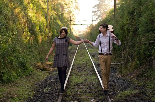 Retro hip hipster romantic love couple walking vintage train tracks