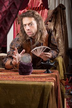 Stoic handsome gypsy man with crystal ball