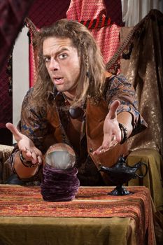 Cute man with crystal ball and open hands