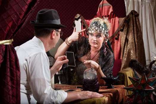 Fortune teller gesturing a gun to her head with customer