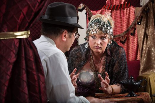 Grimacing lady fortune teller with customer and crystal ball