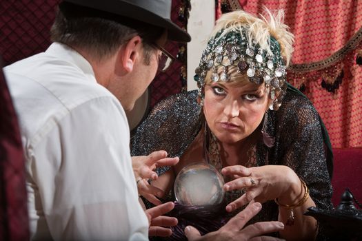 Serious Caucasian fortune teller reading a crystal ball