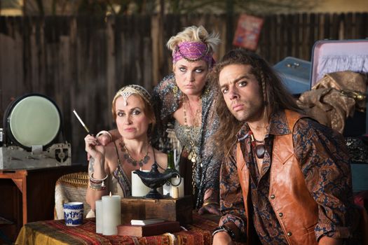 Three fortune teller friends sitting at outdoor kiosk