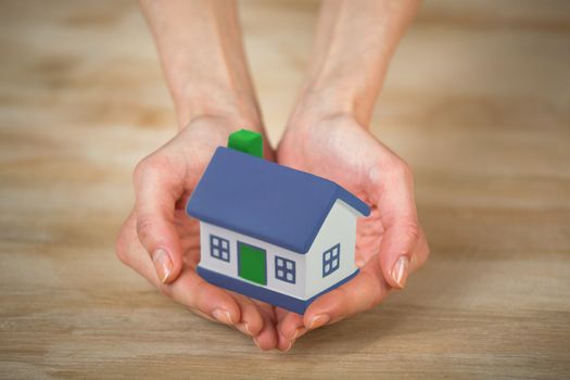 Little House on the hands and the woman. symbol of a successful real estate business.