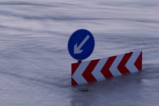 Direction indicator boards on the flooding river