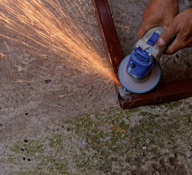 Metal buffing with hand grinder. Sparks while grinding iron.