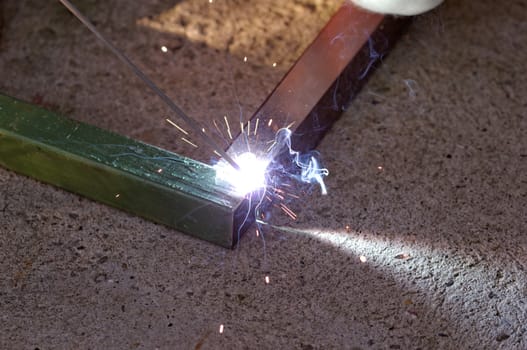 Iron welding with bright light and smoke at manufacturing