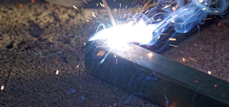 Iron welding with bright light and smoke at manufacturing