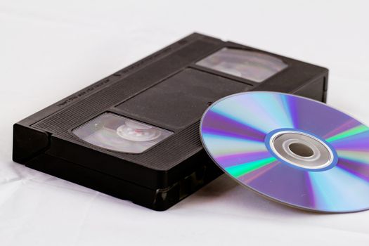 VHS video tape and DVD disk (analog digital) on white background