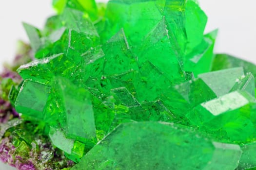 Close up picture about a crystal with emerald color on white background (green crystal)