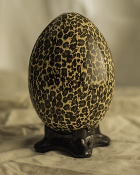 Home decoration piece set as an egg on a stand with leopard print.