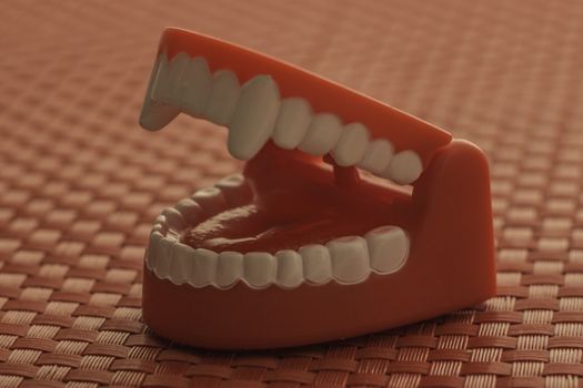 Red background surrounding a child's red toy teeth