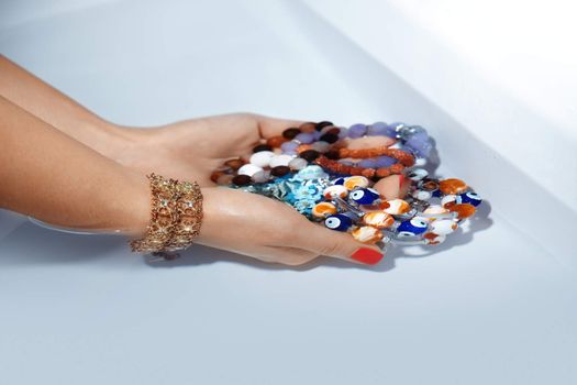 Woman hands holding gems and jewelry under the water