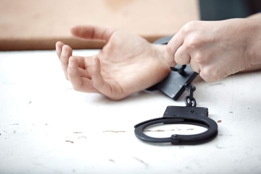 Human hands opening handcuffs. Horizontal close-up photo