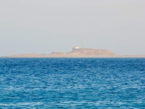 surface of the sea and the island with a lighthouse