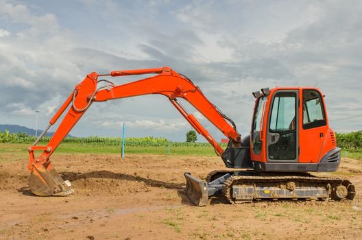 red excavator working in the farmland