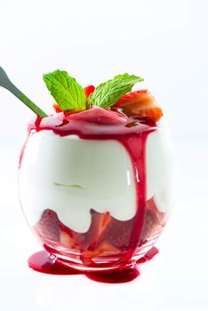 Sweet dessert strawberry and cream in a glass on white background