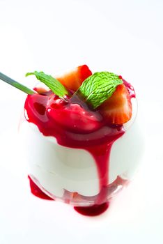 Sweet dessert strawberry and cream in a glass on white background