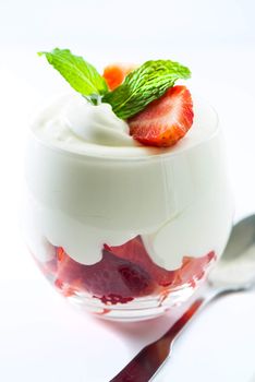 Sweet dessert strawberry and cream in a glass on white background