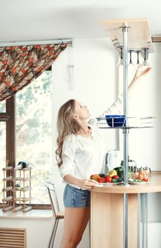 Woman at the kitchen taking wineglass