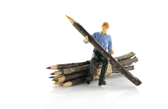 puppet man sitting on bunch of wooden pencils from tree