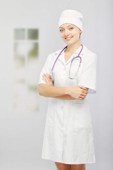 Smiling woman in medical uniform in hospital at the window