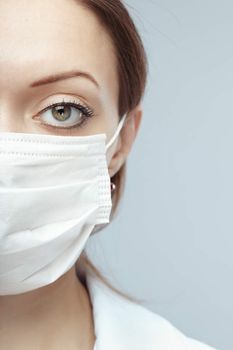 Female doctor in protective mask on a blue background