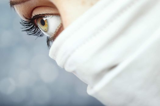 Close-up photo of the female scientist in the protective mask on a blurred background