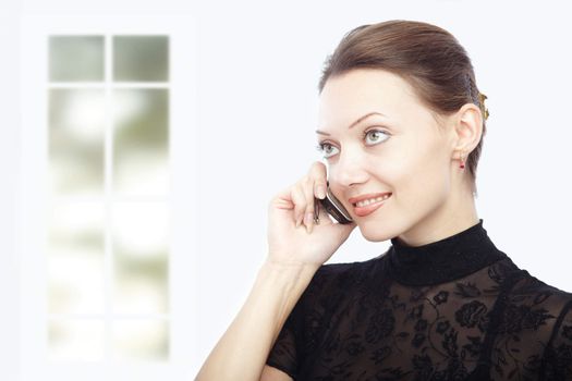 Horizontal photo of the lady talking via cellphone indoors