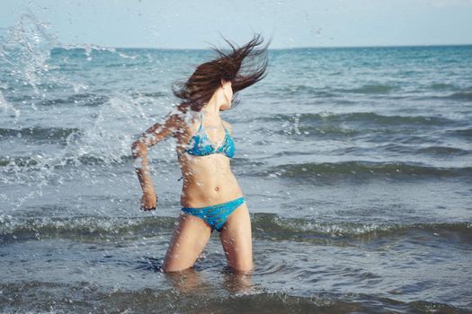 Dynamic lady in the sea and splashing water