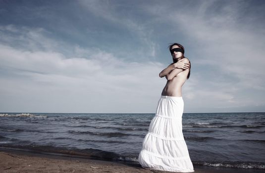 Lady with blindfold stands at the beach