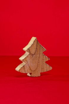 Wood cut shape Christmas tree over red surface