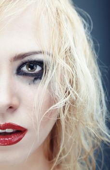 Half face of the blond lady with strange grungy makeup. Vertical photo with natural colors