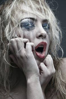 Crazy lady with odd and grungy makeup. Vertical photo. Artistic colors and darkness added
