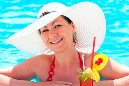 beautiful young girl in the pool with a cocktail